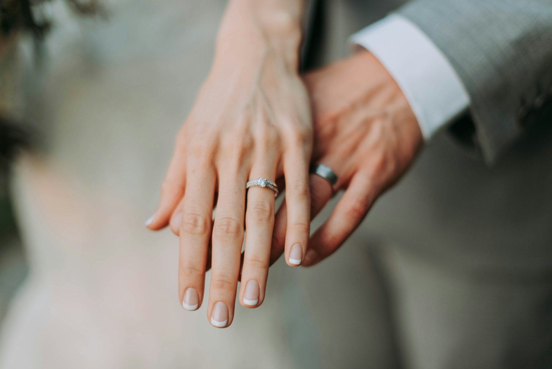 Bride’s and groom’s hands together showing wedding ring and
